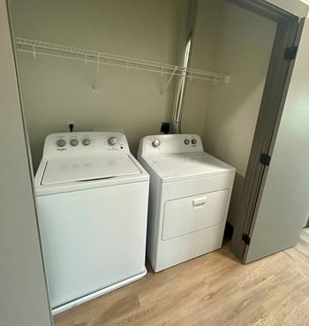 a white washer and dryer in a room with a door